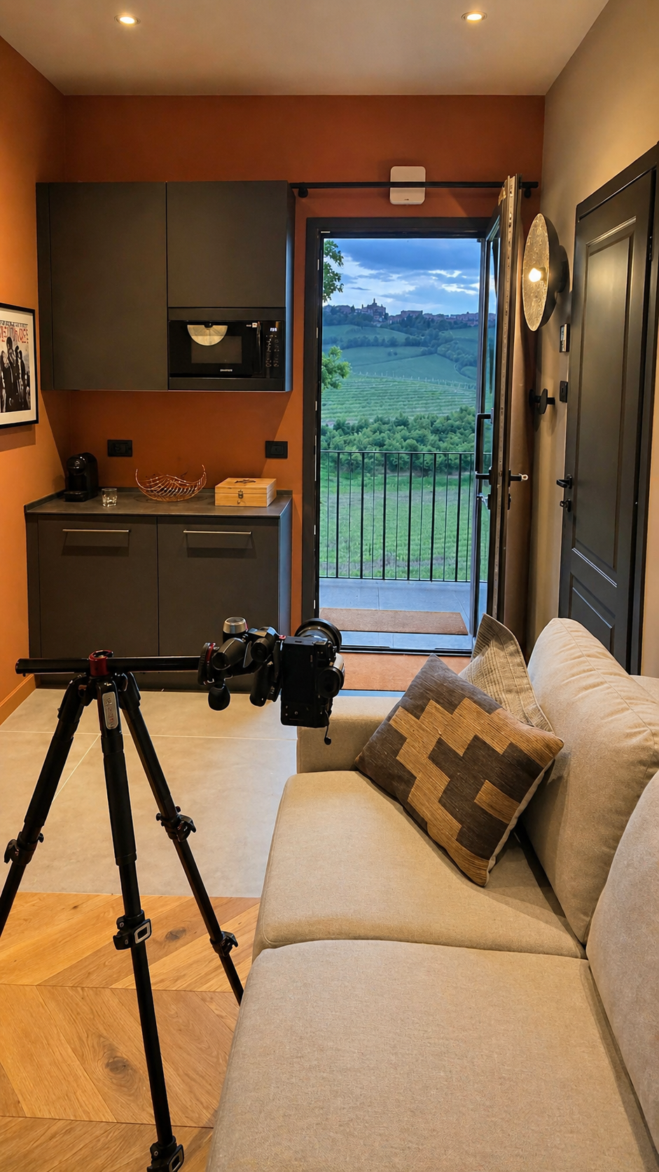 Living room window opening onto the loggia and the Langhe vineyards at dusk